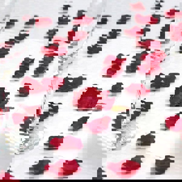 Red petals on a white table cloth