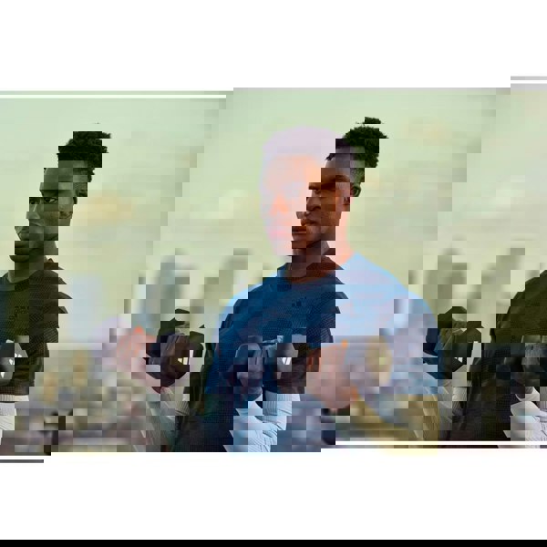 Man holding dumbbells with a cityscape in the background