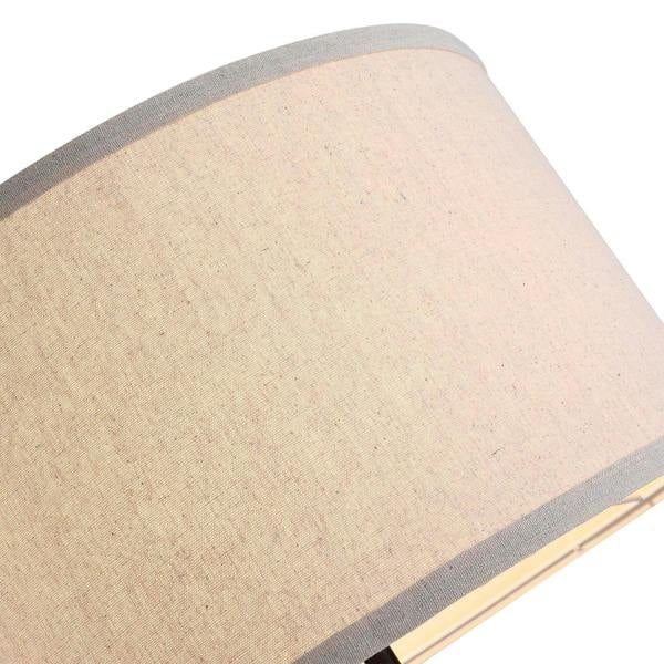 Close-up of beige fabric floor lamp shade with gray trim around the top edge