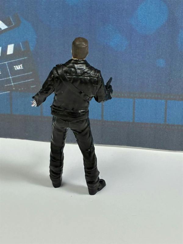 a toy figure of a man pointing at a movie