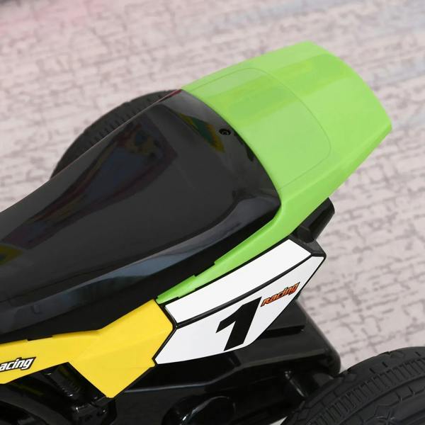 Close-up of green seat and yellow side panel on kids ride-on motorcycle trike with number "1".