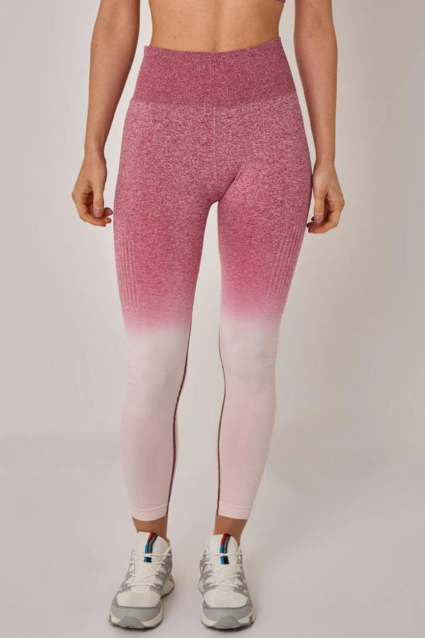 Person wearing pink and purple gradient leggings on a plain background