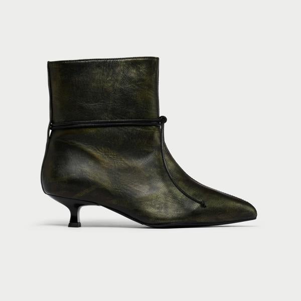 Black leather ankle boot with a pointed toe on a light gray background