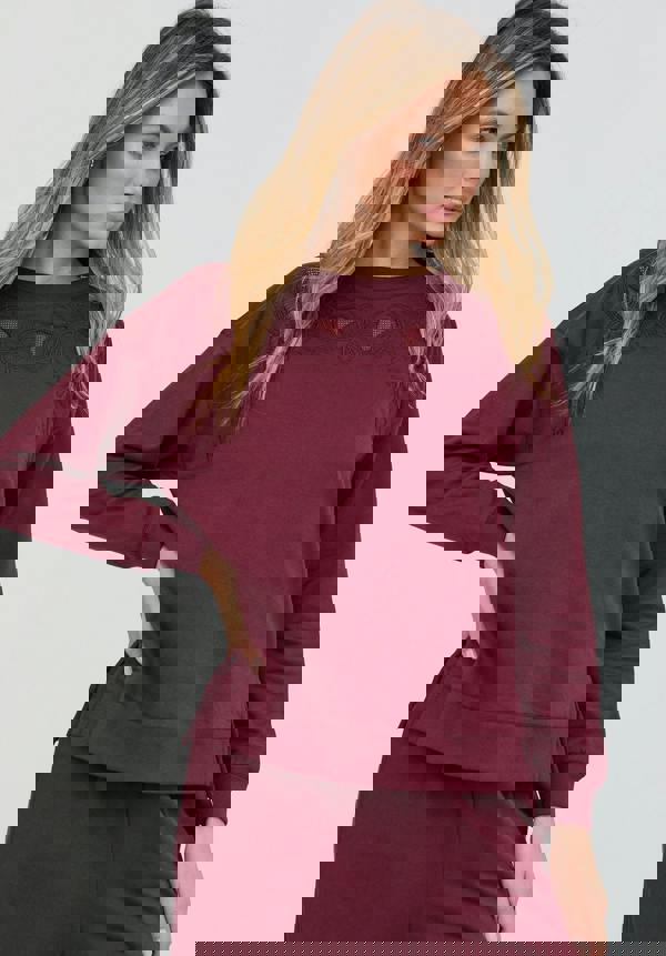Woman wearing a burgundy outfit with a plain background