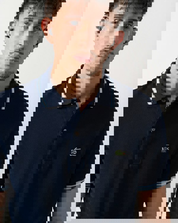 Close up shot of a Model wearing a Lacoste Contrast Collar Pique Mens Regular Fit Polo Shirt in Navy Blue