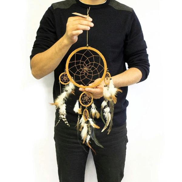 Large round dreamcatcher with brown hoop, web center, and white and black feathers