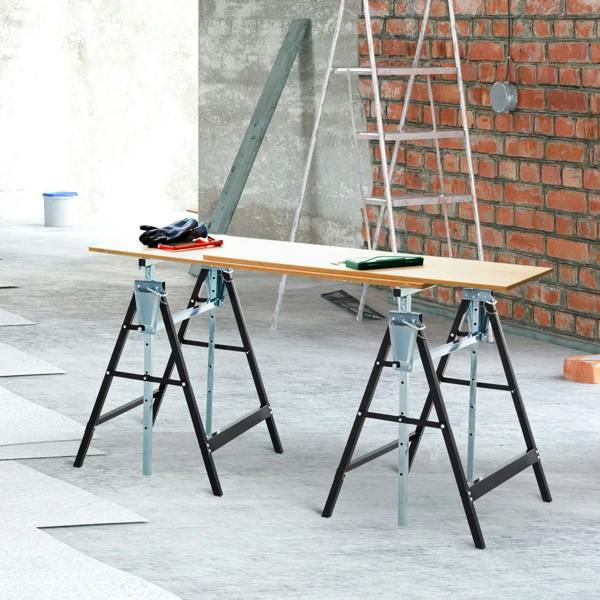 Pair of adjustable steel trestle sawhorses with black legs supporting a wooden worktop
