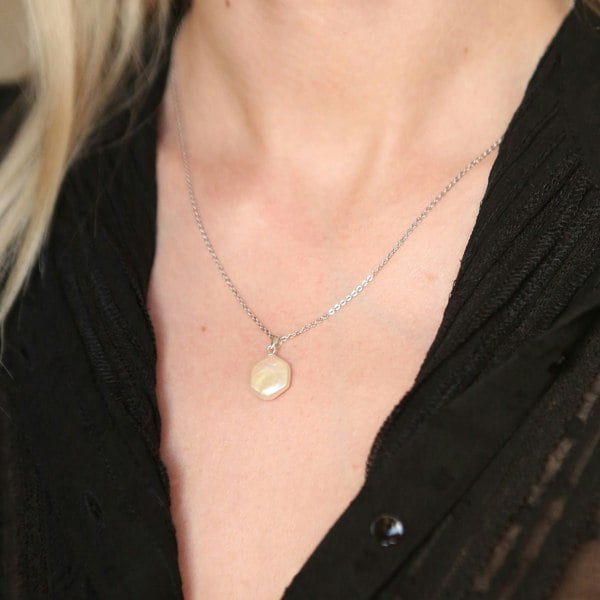 A model wearing hexagonal baroque pearl charm on silver chain.