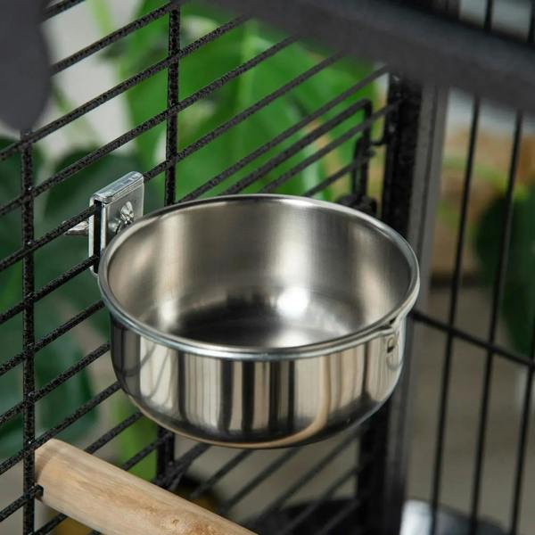 Stainless steel food bowl mounted inside dark grey bird cage