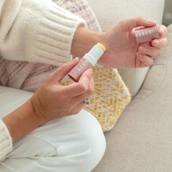 The woman gently smooths the love balm onto her wrist.