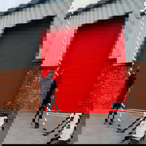 5m vacuum hose in use, extending towards a red garage door, featuring a sturdy design and flexible material for efficient cleaning