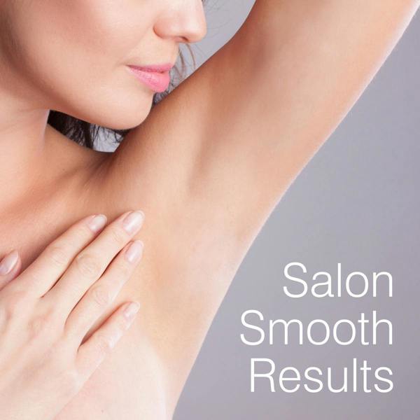 A woman touches her smooth, hair-free underarm with her hand. The text Salon Smooth Results appears, highlighting the benefits of using Rio Coconut Go Smooth Stripless Hard Wax Beads (100g) for beautifully smooth skin.