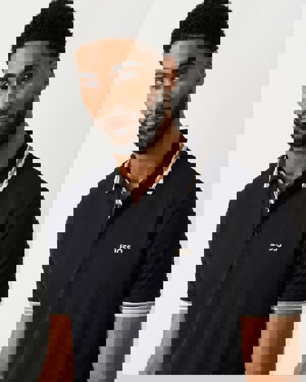 detail shot of a Model wearing a BOSS Green Paddy Mens Cotton-Piqué Polo Shirt with Contrast Logo in Medium Blue