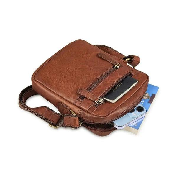 Brown leather bag with a phone and book inside on a white background