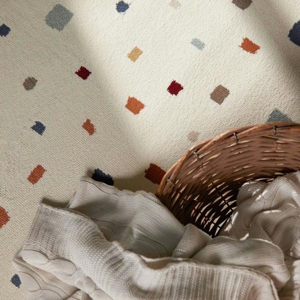 Textured fabric with colorful geometric patterns and a wicker basket on a neutral background