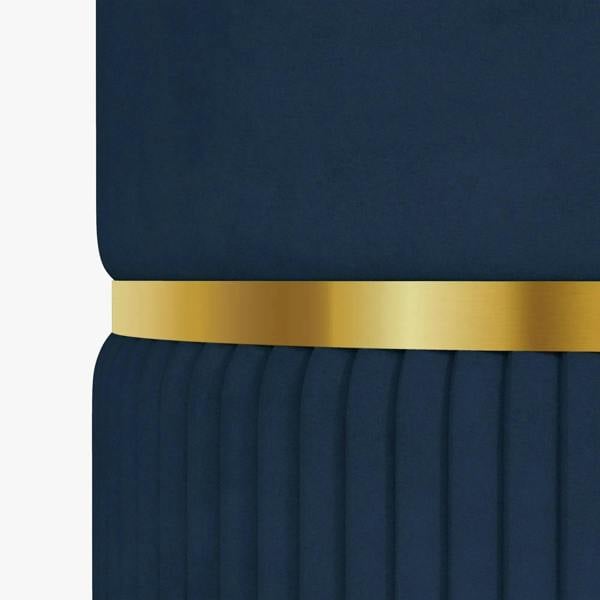Close-up of dark blue ottoman with gold-tone band and vertical fluted fabric texture