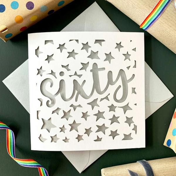 Hand-finished 60th stars papercut birthday card with a colour-matched grey envelope in a compostable bag.