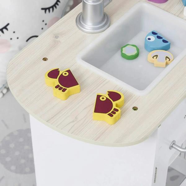 White play kitchen sink area with wooden countertop and small food accessories
