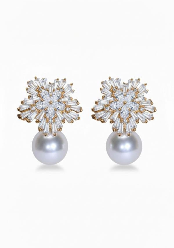 Pair of earrings with star-like top and pearl bottom on a white background