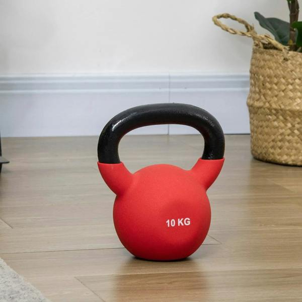 Red 10 kg soft kettlebell standing on wooden floor with black handle