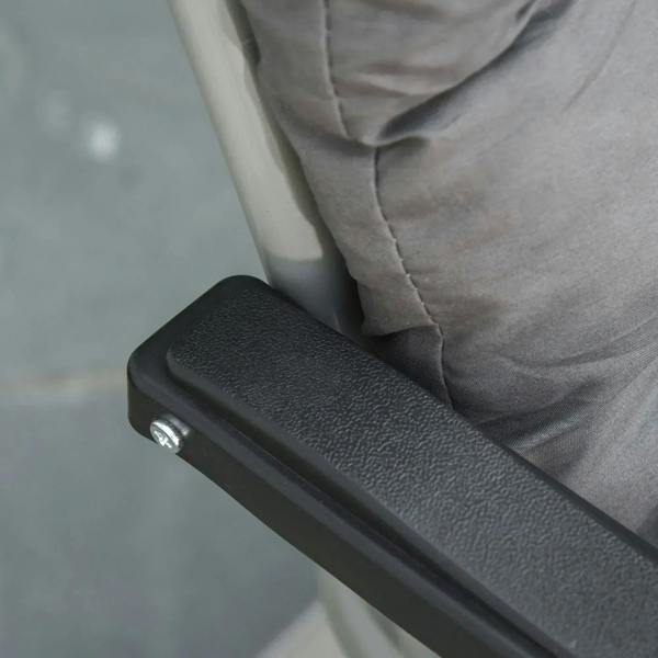Grey cushion on dark frame with textured protective end cover on the armrest