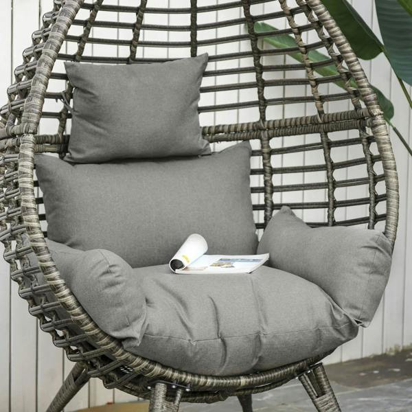 Close-up of grey cushions on wicker egg chair with woven teardrop backrest
