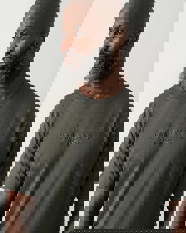 Close up shot of a Model wearing an Armani Exchange Mens T-Shirt with Tonal Milano/New York Logo in Chimera