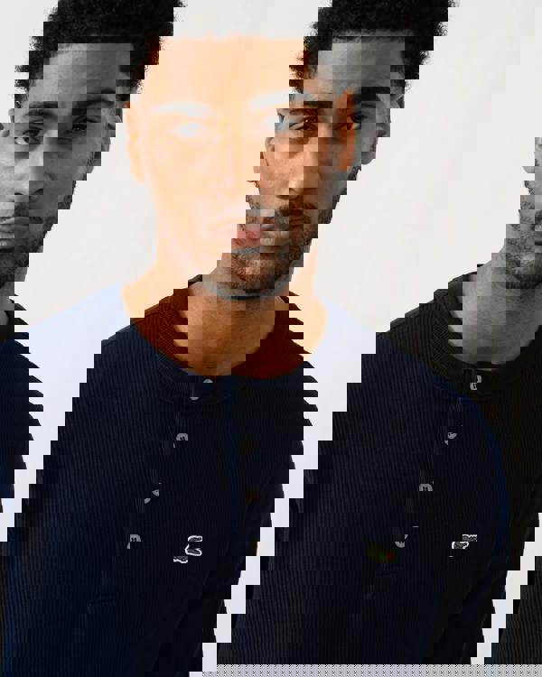 detail view of a model wearing a Lacoste Boxy Tunisian Neck Mens Knit T-Shirt in Navy Blue 166