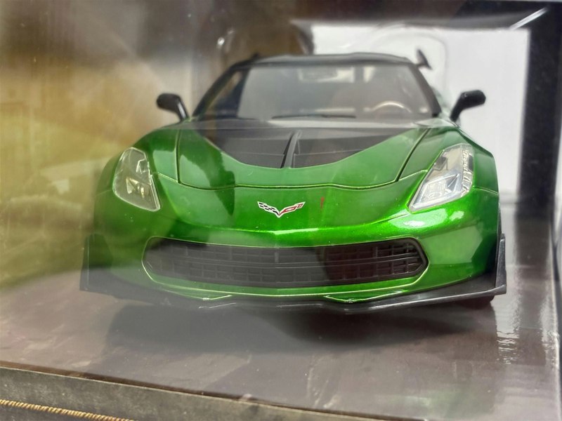 a green sports car in a glass case