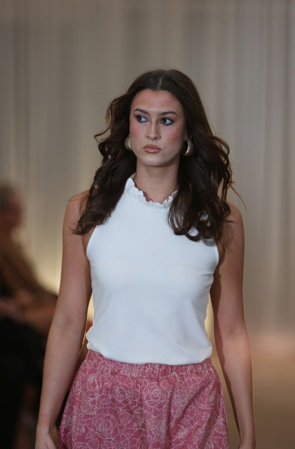 This is a young woman walking towards the camera. She wears this with a cream sleeveless top with ruffle neck.