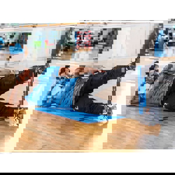 Man exercising in the gym with Fitness Mad Mini Strong around his calves