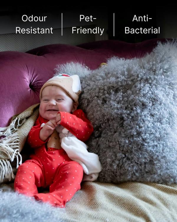 Baby with grey mongolian sheepskin pillow