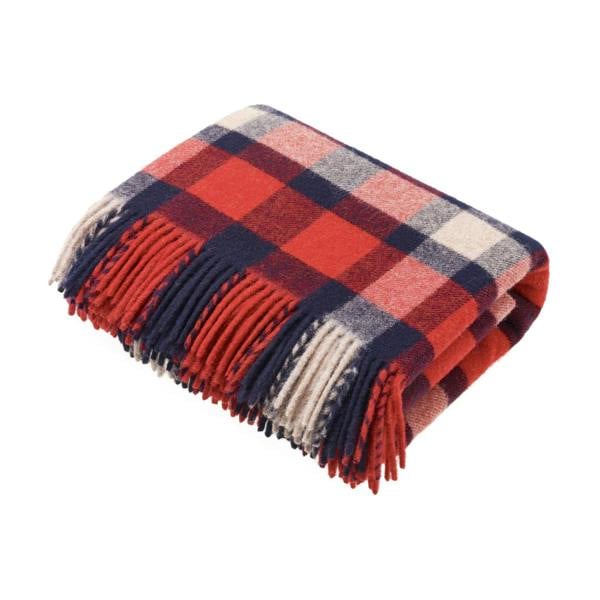 Flatlay image of a wool blanket folded into a small rectangle, the edge of the blanket is fringed, the blanket is multi-coloured check with alternating shades of dark red, faded red, navy, faded navy and cream. Image of the blanket laid out flat with fringing on both edges.