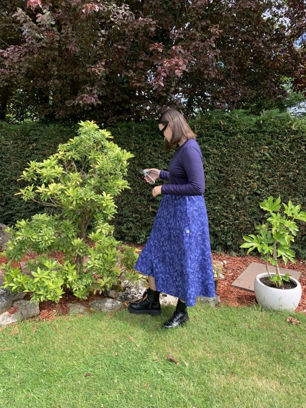 Pictured is the Amiira Dress in Colbalt Waves on our model who is 5"11 and wears a medium. It is long sleeved navy top with a full patterned skirt. 