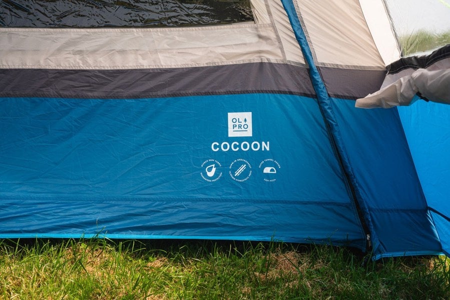 The nameplate on the Cocoon Poled V2 Campervan Awning by OLPRO, it is pitched on a campsite