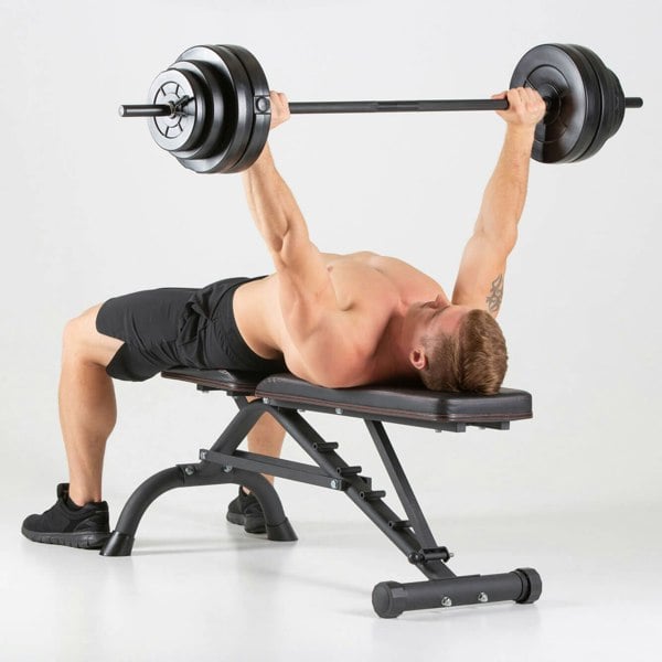Man performing barbell bench press on a HXGN Ultimate Weight Bench 