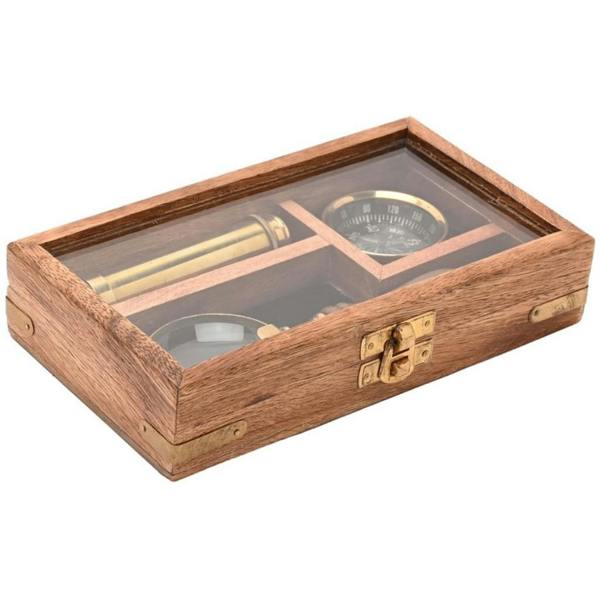 A classic brass explorer gift set inside a closed wooden box with a clear glass lid, showing the compass, telescope, and magnifier on a white background.