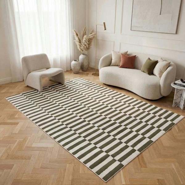 Living room with a striped rug, sofa, and armchair.
