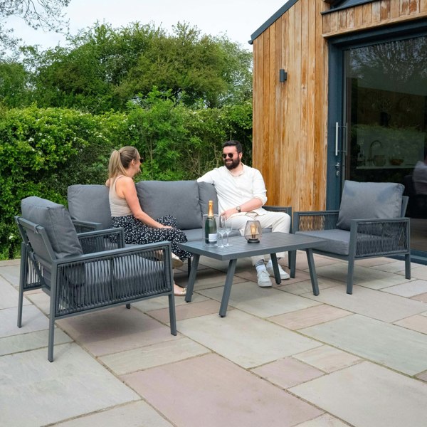 Anthracite 4 piece sofa set with sleek gray cushions, a modern design, and a black parasol, perfect for outdoor lounging and gatherings