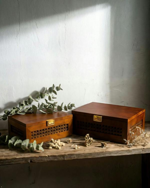 Two wooden boxes with decorative elements on a textured surface