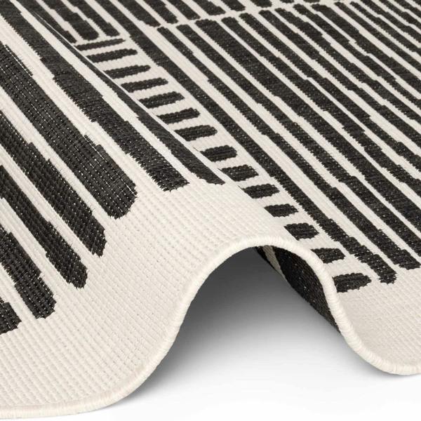 Close-up of a black and white patterned rug with geometric design.
