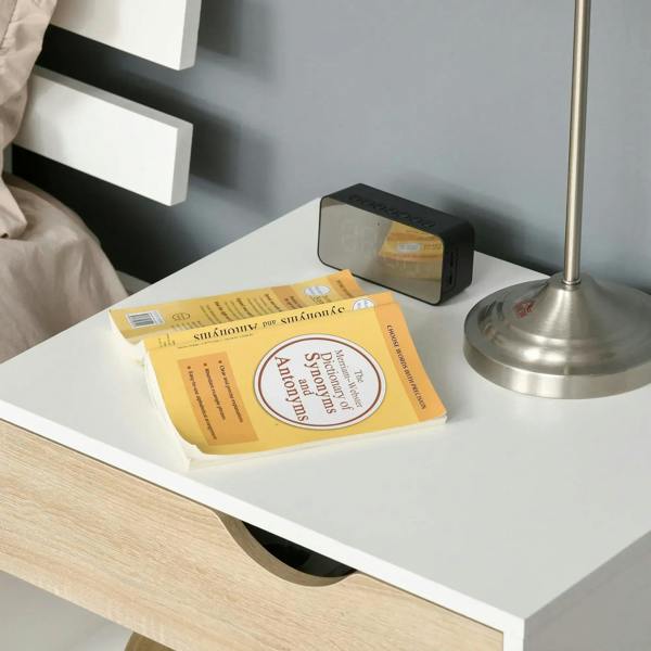 White drawer storage tray with cut-out handle, light wood front, beside a desk lamp.