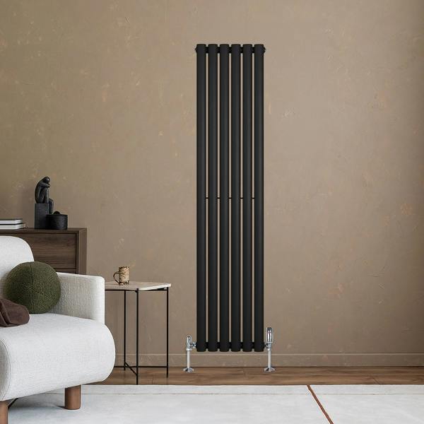 Sleek black oval single column radiator mounted on a textured wall, complemented by stylish valves and modern decor elements