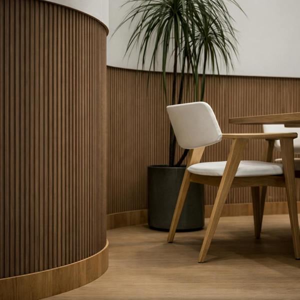 Modern interior with wooden chair, plant, and textured wall.