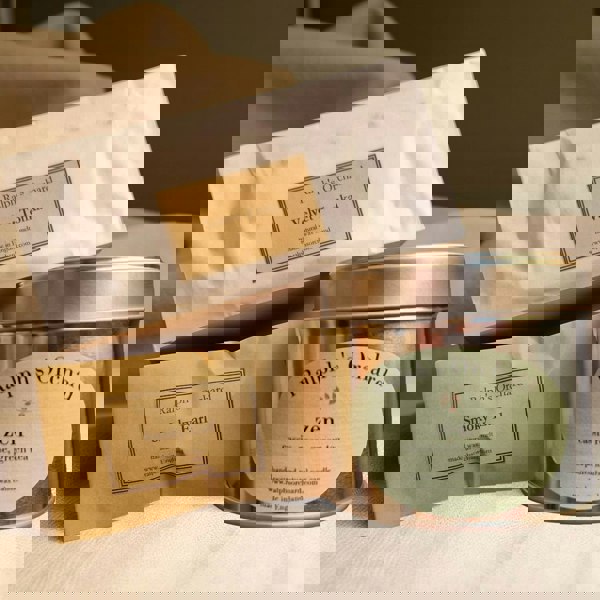 Candle packaging with 'Ralph's Orchard' branding on a neutral background