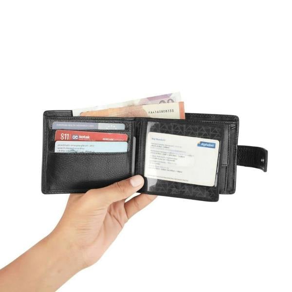 Hand holding a black wallet with cards and money on a white background