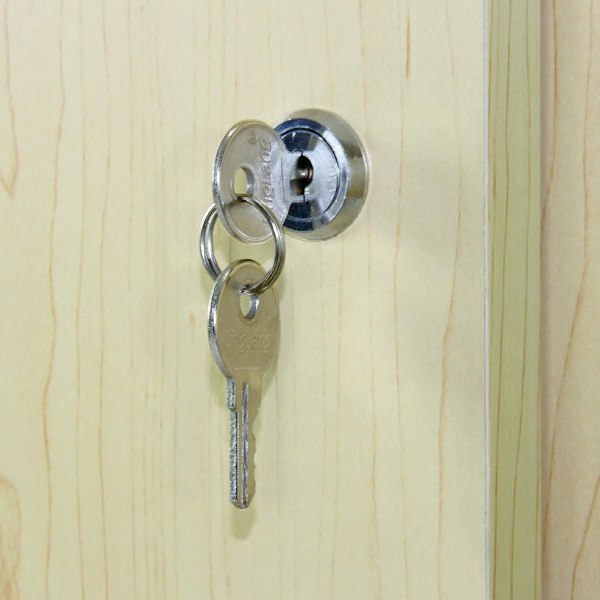 Close-up of a silver key inserted into a round lock on a maple-glazed display counter, showcasing the smooth wood grain finish