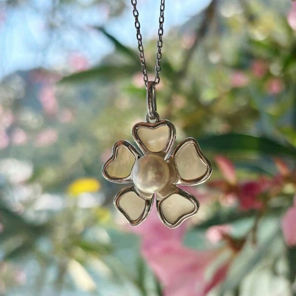Silver floral pendant on silver chain photographer in beautiful nature.