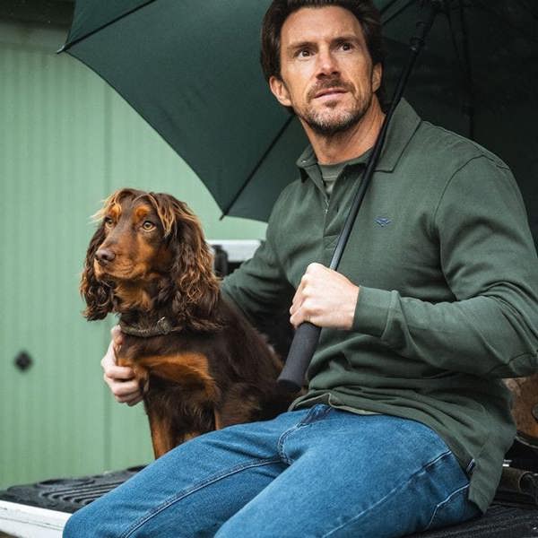 Man in countryside wearing Hoggs of Fife Moffat rugby shirt with dog, showcasing comfortable country lifestyle clothing