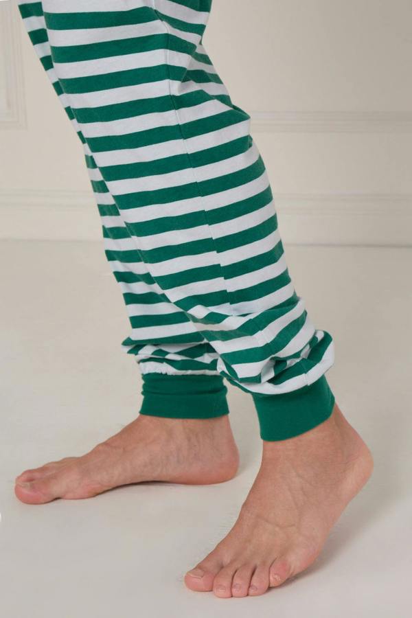Green and white striped pants worn by a person on a plain background